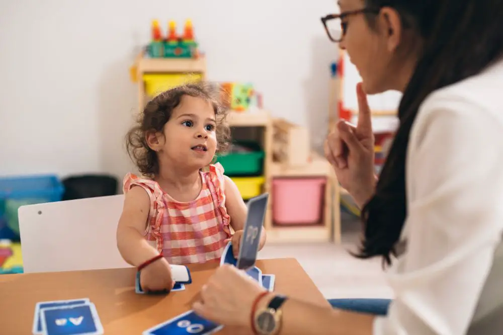 professional woman doing cycles approach speech therapy with a little girl