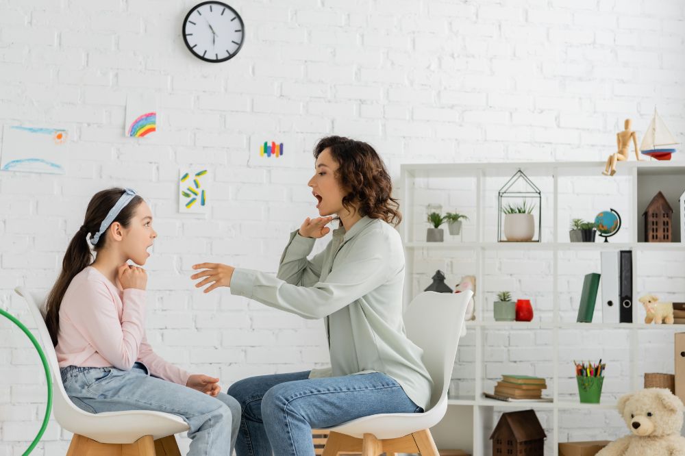 woman doing why questions speech therapy with a young girl